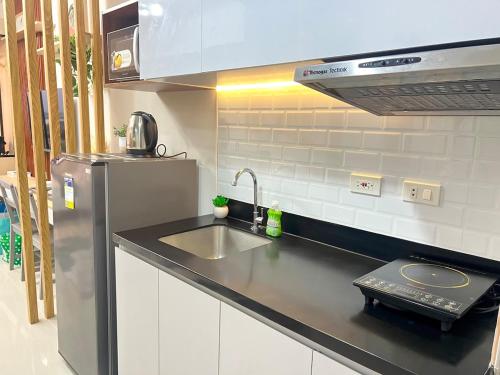 a kitchen with a sink and a refrigerator at J Tower Residences in Mandaue City