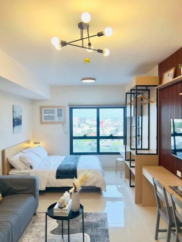 a bedroom with a bed and a living room at J Tower Residences in Mandaue City