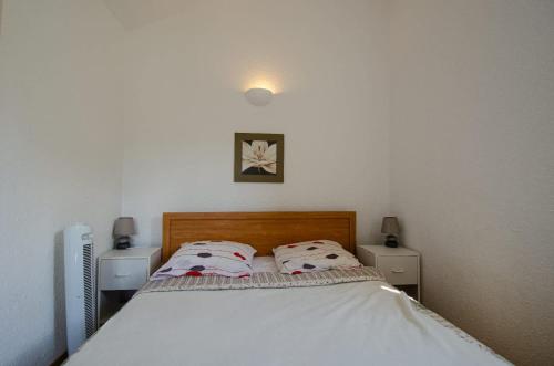 une chambre avec un lit avec deux oreillers dessus dans l'établissement Duplex 2 chambres, vue mer & balcon - 6 couchages, à Porticcio