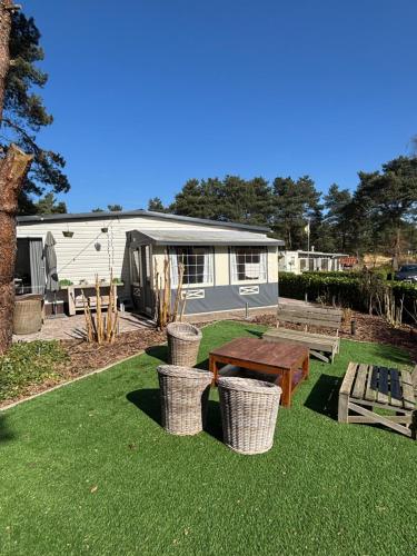 a caravan park with a picnic table and benches at Nomad Laryssiou on camping GT Keiheuvel parcel 371 in Balen