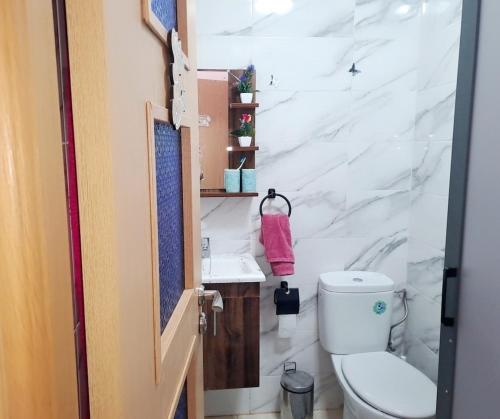 a bathroom with a toilet and a sink at appartement à Mansouria avec piscine et accès a la mer Perla Andaloussia El Mansouria in Mansouria