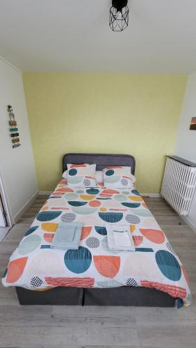 a bed with a colorful comforter in a bedroom at Update Location in Lanester