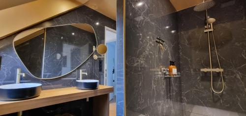 La salle de bains est pourvue de 2 lavabos bleus et d'un miroir. dans l'établissement La Villa Oswar Wilde, à Saint-Martin-Plage