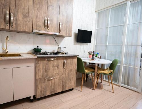 a kitchen with wooden cabinets and a table with chairs at კოსტავას 8 in Tbilisi City