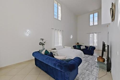 - un salon avec un canapé bleu et un lit dans l'établissement Spacieuse family house pour 14 - Disneyland Paris, à Magny-le-Hongre