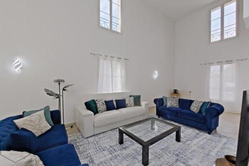 un salon avec deux canapés bleus et une table dans l'établissement Spacieuse family house pour 14 - Disneyland Paris, à Magny-le-Hongre