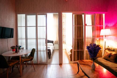 a living room with a table and a room with a bed at კოსტავას 8 in Tbilisi City