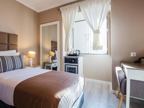 a bedroom with a bed and a window at Vila Garden Guesthouse in Lisbon