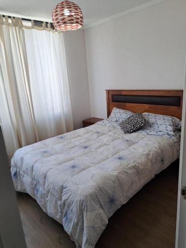 a bedroom with a bed and a chandelier at Céntrico Dpto Calama in Calama