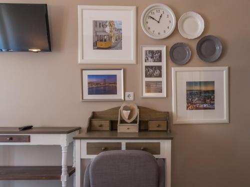 a room with a desk and a clock on the wall at Vila Garden Guesthouse in Lisbon