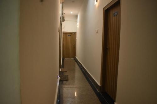 a hallway with a long corridor with a door at Hasimara River View Home Stay in Hāsimāra