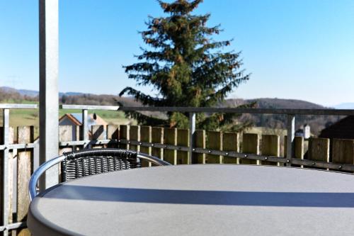 a table and chairs and a tree on a patio at Gasthaus Adler in Nordschwaben