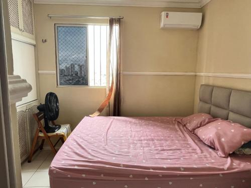 a bedroom with a pink bed with a window at Apto estratégico COP30 in Belém
