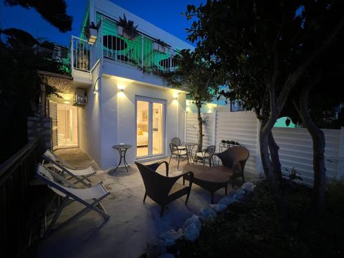 a patio with chairs and a table at night at La Reginella Capri in Capri