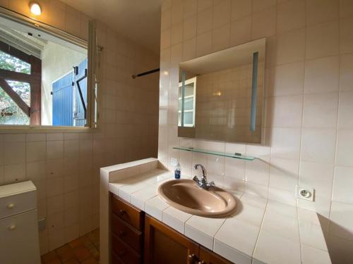 une salle de bain avec un lavabo et un miroir dans l'établissement Grande maison landaise près du port de Capbreton, 4 chambres, jardin, animaux admis - FR-1-413-232, à Capbreton