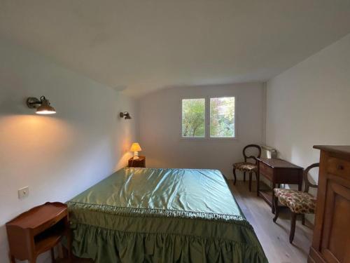une chambre avec un lit, une table et une fenêtre dans l'établissement Grande maison landaise près du port de Capbreton, 4 chambres, jardin, animaux admis - FR-1-413-232, à Capbreton