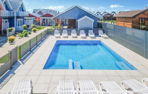 una piscina con tumbonas y una piscina en Lovely Home In Sarbinowo With Wifi, en Sarbinowo