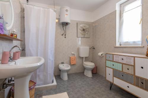 a bathroom with a sink and a toilet and a shower at Villa Jordan, a charming Villa near the sea, with garden & pool in Nedeščina