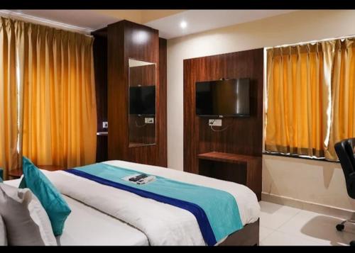a bedroom with a large bed and a television at Hotel KGB Coolriver in Visakhapatnam