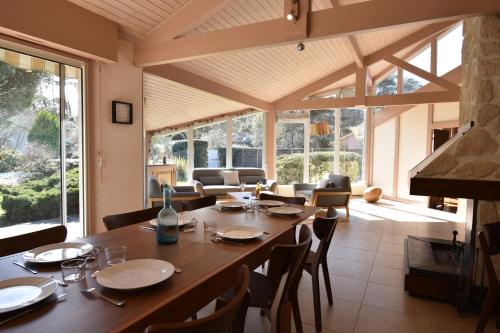 une salle à manger avec une grande table et des chaises en bois dans l'établissement Hossegor Belle villa avec piscine pour 10 personnes., à Hossegor