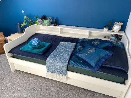 a white bed with blue sheets and blue pillows at Peverell Loft Retreat in Plymouth