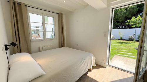 une chambre avec un lit et une grande fenêtre dans l'établissement Villa de luxe avec piscine pour 12 personnes, à La Couarde-sur-Mer
