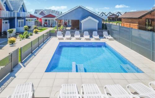 una piscina con tumbonas y una piscina en 2 Bedroom Beautiful Home In Sarbinowo, en Sarbinowo