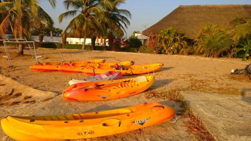a group of kayaks lined up on a beach at Hôtel Katakalousse in Yembakana