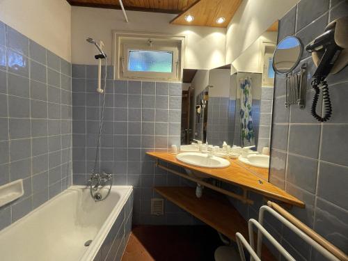 une salle de bain avec deux lavabos et une baignoire dans l'établissement Alpee 4 - Appartement proche pistes de ski, à La Clusaz