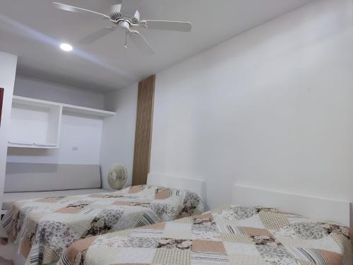 two beds in a room with a ceiling fan at Casa, Anapoima Cundinamarca in Anapoima