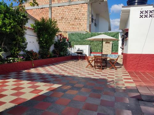 a patio with a table and chairs and an umbrella at Casa, Anapoima Cundinamarca in Anapoima