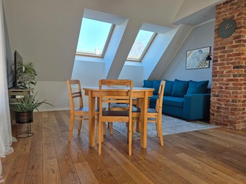 a dining room with a table and chairs and a blue couch at Home away home in Tartu