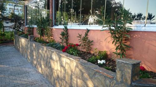 a retaining wall with flowers in front of a building at Hotel Grün in Kızılot