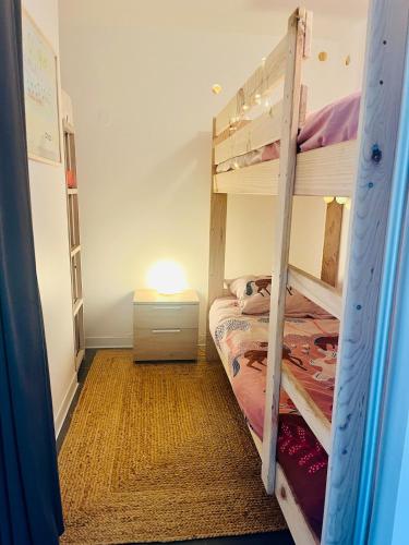 une chambre avec deux lits superposés et une lampe dans l'établissement Apt T3 avec terrasse, sous les pins, au bord du lac et à 5 min de l'océan, à Carcans