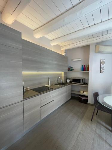 a kitchen with stainless steel cabinets and a table at L'angolo di mare [Centro di Sirolo] in Sirolo