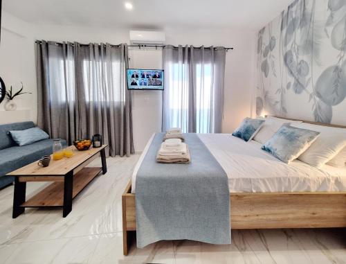 a bedroom with a large bed and a table at Coastal Ierapetra 2 in Ierapetra