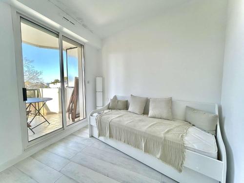 une chambre blanche avec un lit et un balcon dans l'établissement Appartement calme avec terrasse à 2 pas de la plage Benoît, 2 pièces, 4 couchages, La Baule - FR-1-245-103, à La Baule