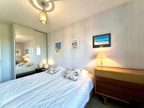 une chambre avec un lit, une commode et un miroir dans l'établissement Appartement T3 Face Mer à La Baule avec Terrasse et Parking Privé, 4 Couchages - FR-1-245-97, à La Baule