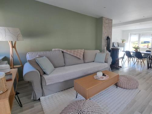 un salon avec un canapé et une table dans l'établissement le refuge du bonheur, à Bitche