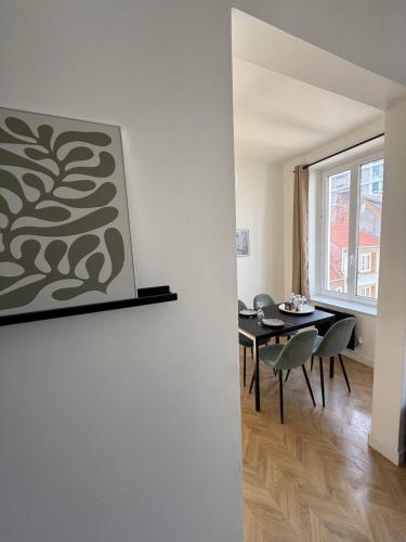 une salle à manger avec une table et des chaises ainsi qu'une peinture murale. dans l'établissement L'OpalEscale - Appartement à 5min à pied de Nausicaa, plage, centre Ville, à Boulogne-sur-Mer