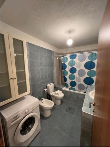 a bathroom with a washing machine and a toilet at TranquilityHouse in Tríkala