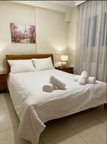 a bedroom with a white bed with towels on it at TranquilityHouse in Tríkala