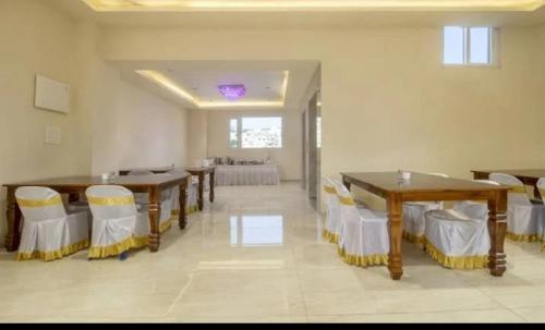 a large room with tables and chairs and a dining room at Hotel KGB Coolriver in Visakhapatnam