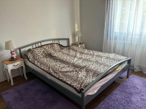 a bed in a bedroom with two tables and two lamps at Village house & Micro Winery in Sîntioana de Mureş