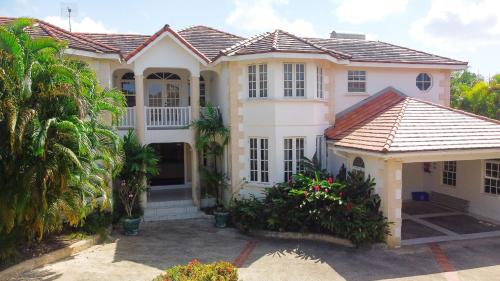 a large white house with a porch at Marzalea 4 bd Villa by ZenBreak in Saint James