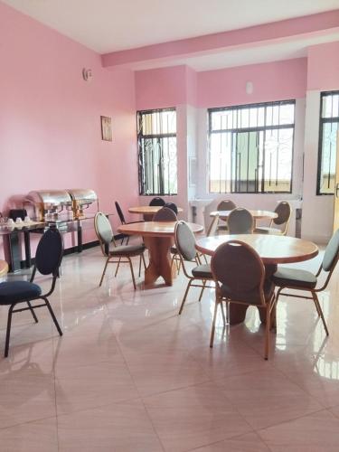 a room with tables and chairs and windows at Sweetland view hotel in Lushoto