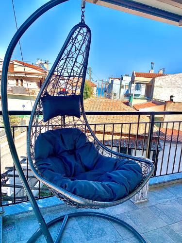 a blue pillow in a swing on a balcony at Zeffie's Studio in Olympiada