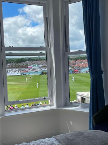 a bedroom with two windows with a view of a field at Keepers Rest Apartment - Scarborough in Scarborough