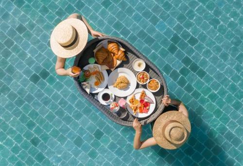 two people holding a table of food in a pool at Krabi Tipa Resort in Ao Nang Beach
