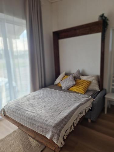 a bed with a blanket and pillows on it at Taadi studio apartment in Loosu